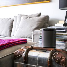 a living room filled with furniture and a large metal container sitting on top of a couch