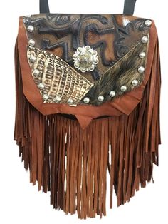 Handmade of velvety soft brown deerskin with a 7" brown deerskin fringe. The flap features genuine alligator, hair-on-hide and printed leather. The centerpiece is a striking silver concho. Etched silver metal studs trim the outline of the bag. Wear bag clipped to belt loops for hands-free carrying of your essentials. Interior includes a leather strap. Add the strap when you want a completely different look. Hand Tooled Leather Bag, Artisan Brown Bag With Leather Backing, Unique Brown Bag For Everyday Use, Unique Hand-stitched Bags For Everyday Use, Hand Tooled Brown Bag, Western Style Fringed Bags For Everyday Use, Unique Hand Tooled Brown Bag, Unique Hand-tooled Brown Bag, Fur Bags