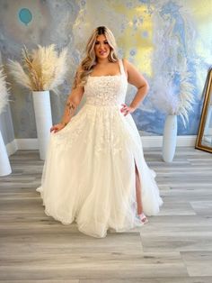 a woman standing in front of a mirror wearing a white dress