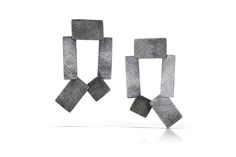 Silver Earrings - These fabricated and cast drop earrings are composed of lightweight, hinged planes of oxidized sterling silver covered with the artists signature carved texture.<br><br>The geometric shapes are stacked and layered, forming a wearable sculpture with incredible movement. Sterling silver posts. Tab Earrings, Wearable Sculpture, Artful Home, Oxidized Sterling Silver, Precious Metals, Geometric Shapes, Silver Earrings, Original Art, Handmade Jewelry