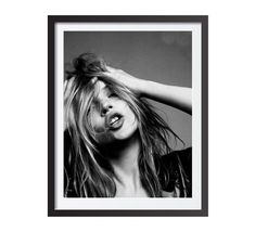 a black and white photo of a woman with her hair blowing in the wind,