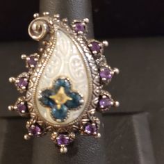 Carved Mop Is Surrounded By Amethysts. In The Center Is The Iconic Bixby Flower In Blue Topaz With A Touch Of 18k In The Center. Like-New Condition. This Item Is From My Personal Collection. I Purchased It New. Victorian Sterling Silver Rings In Purple, Victorian Style Hallmarked Purple Rings, Barbara Bixby Rings, Bohemian Sterling Silver Purple Rings, Ornate Hallmarked Amethyst Ring In Sterling Silver, Bohemian Sterling Silver Cabochon Crystal Ring, Womens Jewelry Rings, Blue Topaz, Topaz