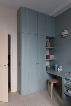 a bedroom with blue walls and furniture in the corner, including a desk and chair