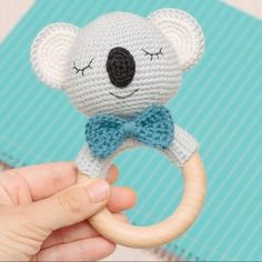 a hand holding a crocheted koala bear ring