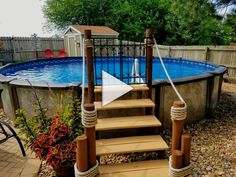 an above ground swimming pool with steps leading up to it and a roped in deck