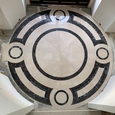 an overhead view of a circular marble table with black and white designs on it's surface