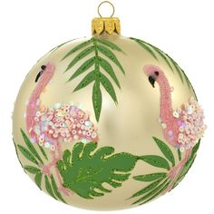 a glass ornament with pink flamingos and green leaves