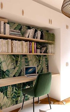 a laptop computer sitting on top of a wooden desk in front of a bookshelf