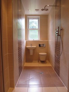 a bathroom with a toilet, sink and shower head in the wall next to it