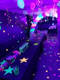 a party room with balloons, streamers and confetti on the floor at night