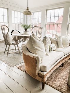 a living room filled with furniture and lots of windows