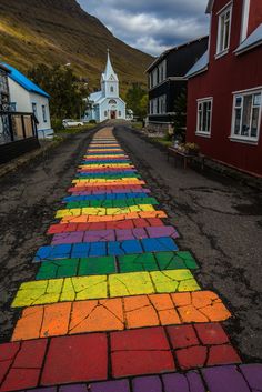 a rainbow painted road leading to a church