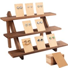 a wooden display case with earrings and earring holders on it, next to some cards