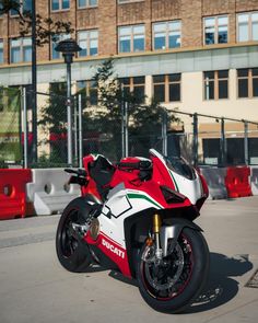 a red and white motorcycle parked in front of a building