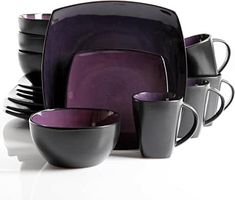 a purple and black dinnerware set on a white background