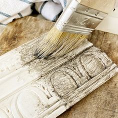 a brush is being used to paint a piece of wood