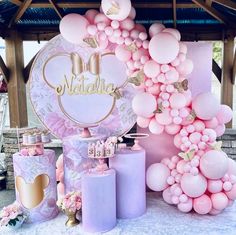 pink and gold balloons are on display at a birthday party