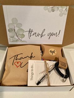 a thank you box is open and has writing on the inside, along with other items