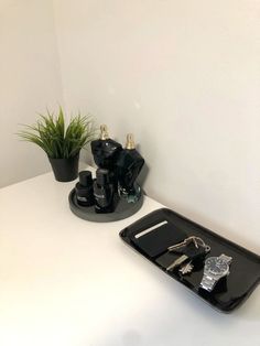 there is a tray with keys on it and a plant in the corner next to it