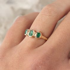 Three emeralds are embedded into this magical piece of treasure! Bezel set in 14k gold, this ring is inspired by ancient jewelry. Currently size 5.5 Due to the nature of the settings, this ring can only be resized up or down 1 size, if you need a size that is outside of the 1 size range, email me! Depending on my stock, I can make you a custom ring in any size! The inclusions and imperfections on these stones are natural. I choose to use perfectly imperfect stones because of the personality they Timeless Green Open Ring Emerald, Timeless Green Emerald Open Ring, Timeless Yellow Gold Emerald Birthstone Ring, Heirloom Three-stone Emerald Ring, Emerald Ring With Bezel Setting For May Birthstone, Timeless 14k Stamped Green Emerald Ring, Timeless Green Emerald Ring Stamped 14k, Timeless Emerald Birthstone Ring, Heirloom Tsavorite Emerald Ring In Gold