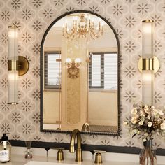 a bathroom with a sink, mirror and chandelier in front of the wall