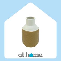 a white and brown vase sitting on top of a blue background with the words at home above it