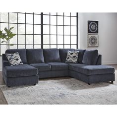 a blue sectional sofa with pillows on it