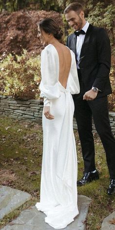 a man in a tuxedo and a woman in a white dress standing next to each other