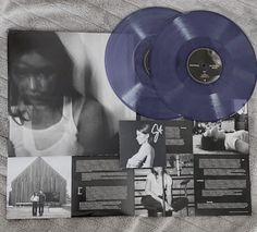 two blue vinyl records sitting on top of a bed next to an album and magazine