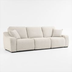 a white couch with four pillows on it's back and one arm facing the camera