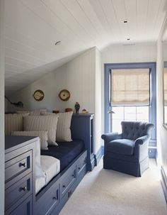 an attic bedroom with blue furniture and white walls