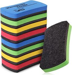 multicolored foam sponges are stacked on top of each other in front of a white background