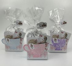 three tea bags and two mugs with designs on them