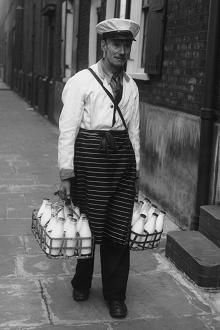 an old man holding two baskets full of eggs