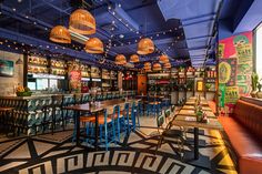 the interior of a restaurant with tables, chairs and bar stools in front of it