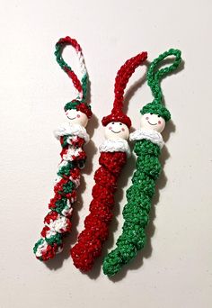 two crocheted christmas candy canes with santa hats on them