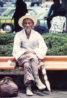 an old man sitting on a park bench