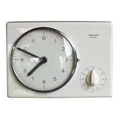 an analog clock with thermometer on it's side