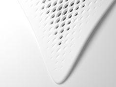 a close up view of the side of a white object with holes and lines on it