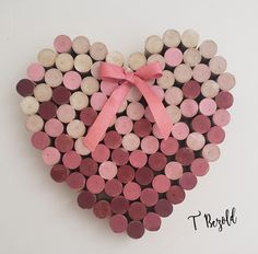 a heart made out of wine corks with a pink bow