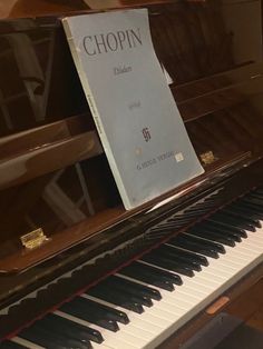 a piano with a book on top of it sitting in front of a piano keyboard