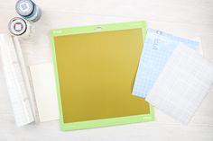 craft supplies laid out on top of a white wooden table with scissors, tape and paper