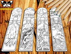 three bookmarks with different designs and pencils next to them on a wooden table