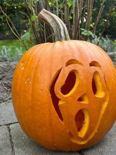 a carved pumpkin sitting on top of a sidewalk