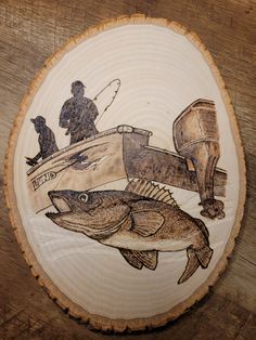 a wood slice with a fishing scene painted on it