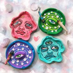 four colorful plates with faces painted on them