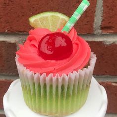 a cupcake with a cherry and lime on top