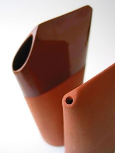 two brown vases sitting next to each other on a table