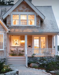 a house that is lit up at night with lights on the front and side windows