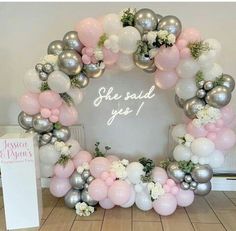 a wreath made out of balloons and flowers with a sign that says life said yes